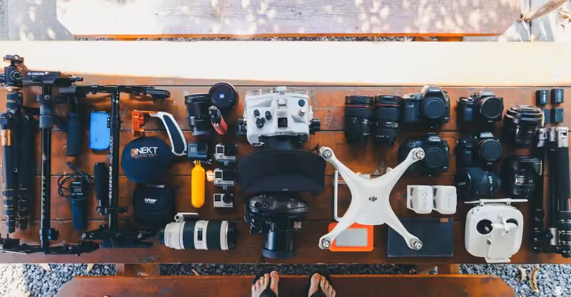 Dron, baterías, cámaras y accesorios organizados sobre una mesa antes de una salida de vuelo