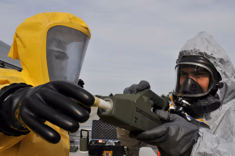 Técnicos con traje de protección química y equipo de detección durante un ejercicio de materiales peligrosos