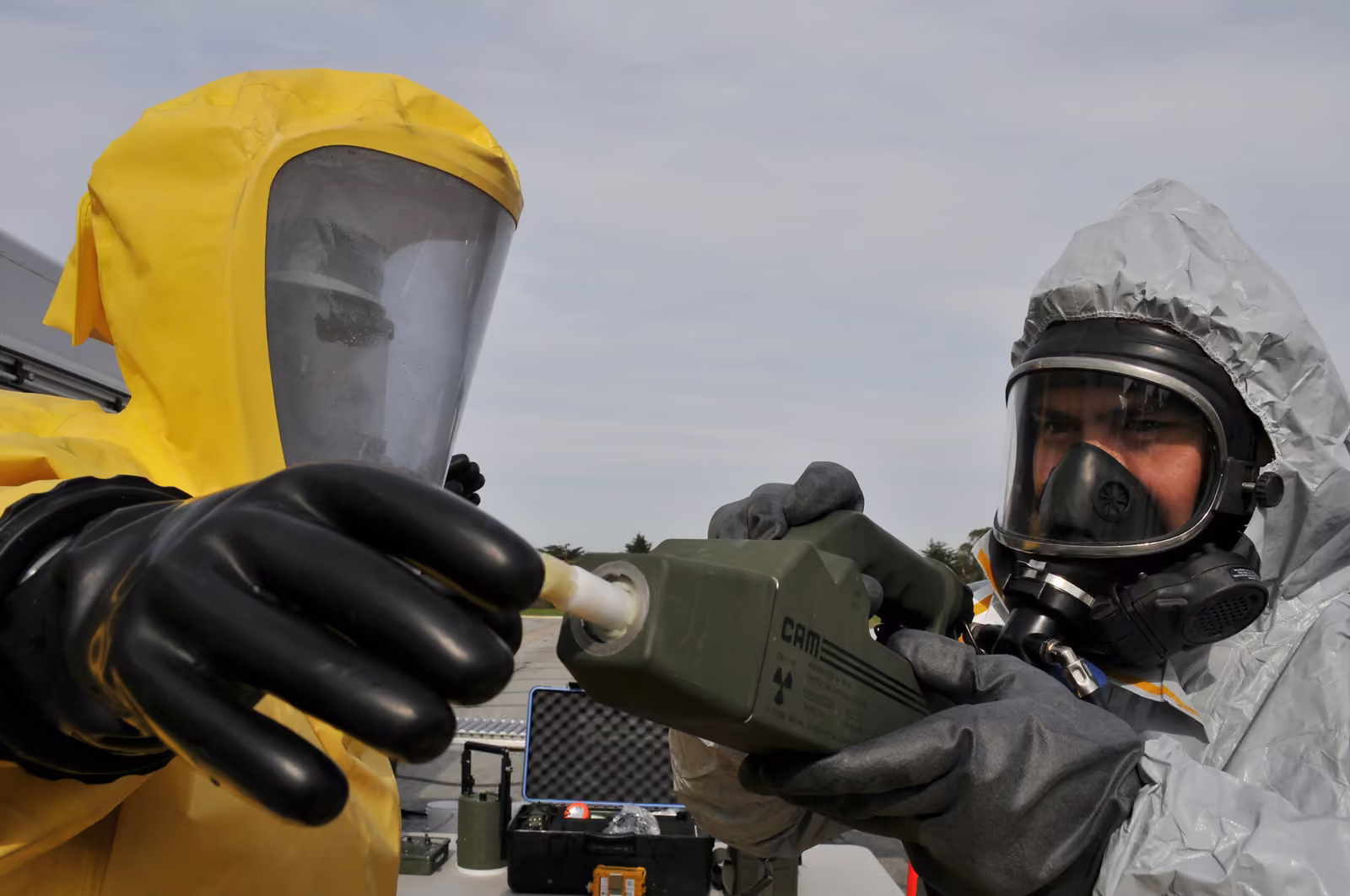 Técnicos con traje de protección química y equipo de detección durante un ejercicio de materiales peligrosos